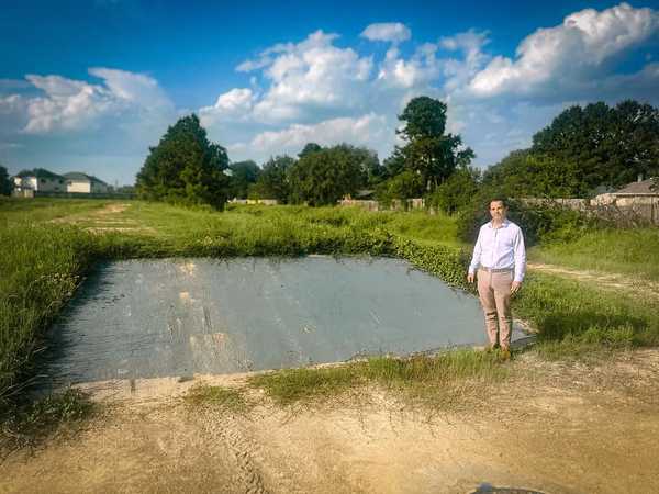 Man standing in front of concrete pad that has had graffiti removed